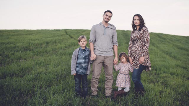 Family with two kids on green field - Small